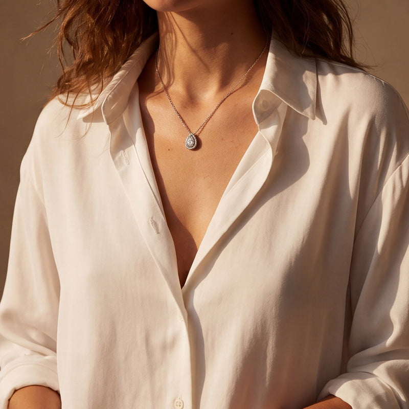Model wearing the pear halo necklace with a silk shirt