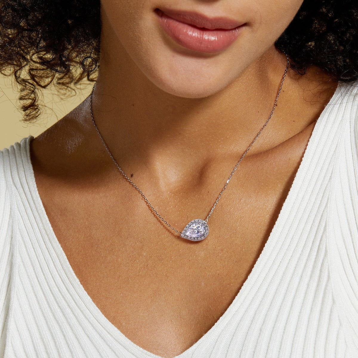 Model wearing the sideways pear halo necklace